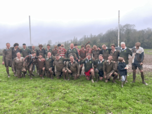 Harrow football - Little Green Consulting The Little Green Men Harrow football team all stood in a team. They're all covered in mud after the game