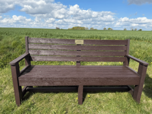 Kathryns bench - Little Green Consulting Kathryn's memorial bench sat in a green field with blue skies.